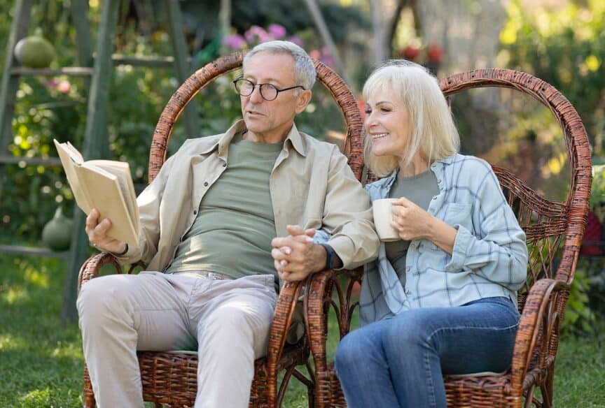 old man and woman sitting together while reading a book