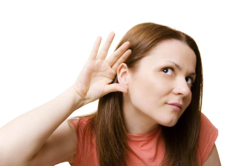 woman cups ear to hear better